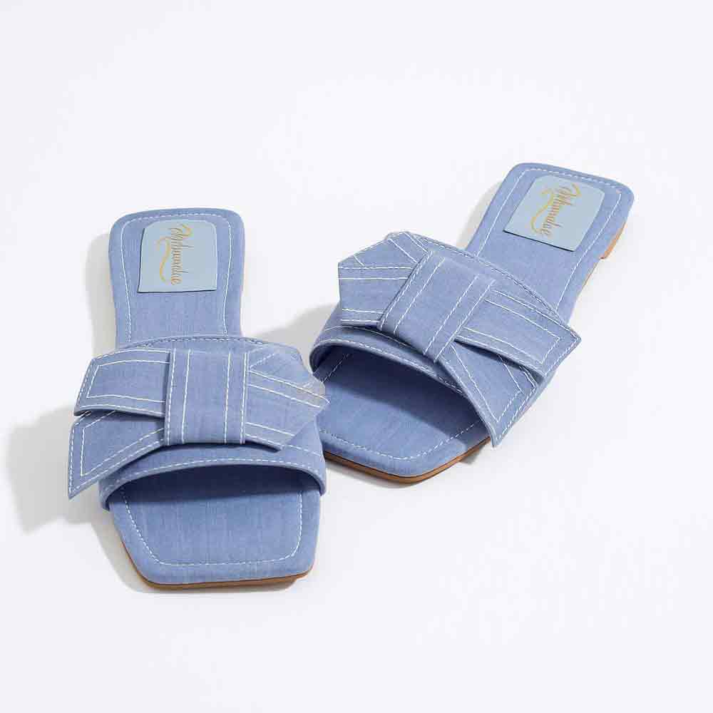 Pair of blue sandals with strap details on a white background